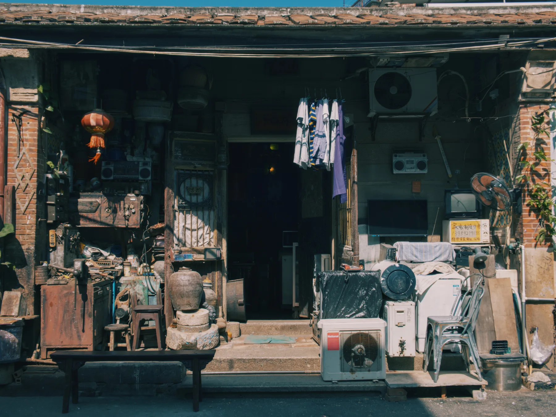 Quiet storefront and hanging clothes in warm light