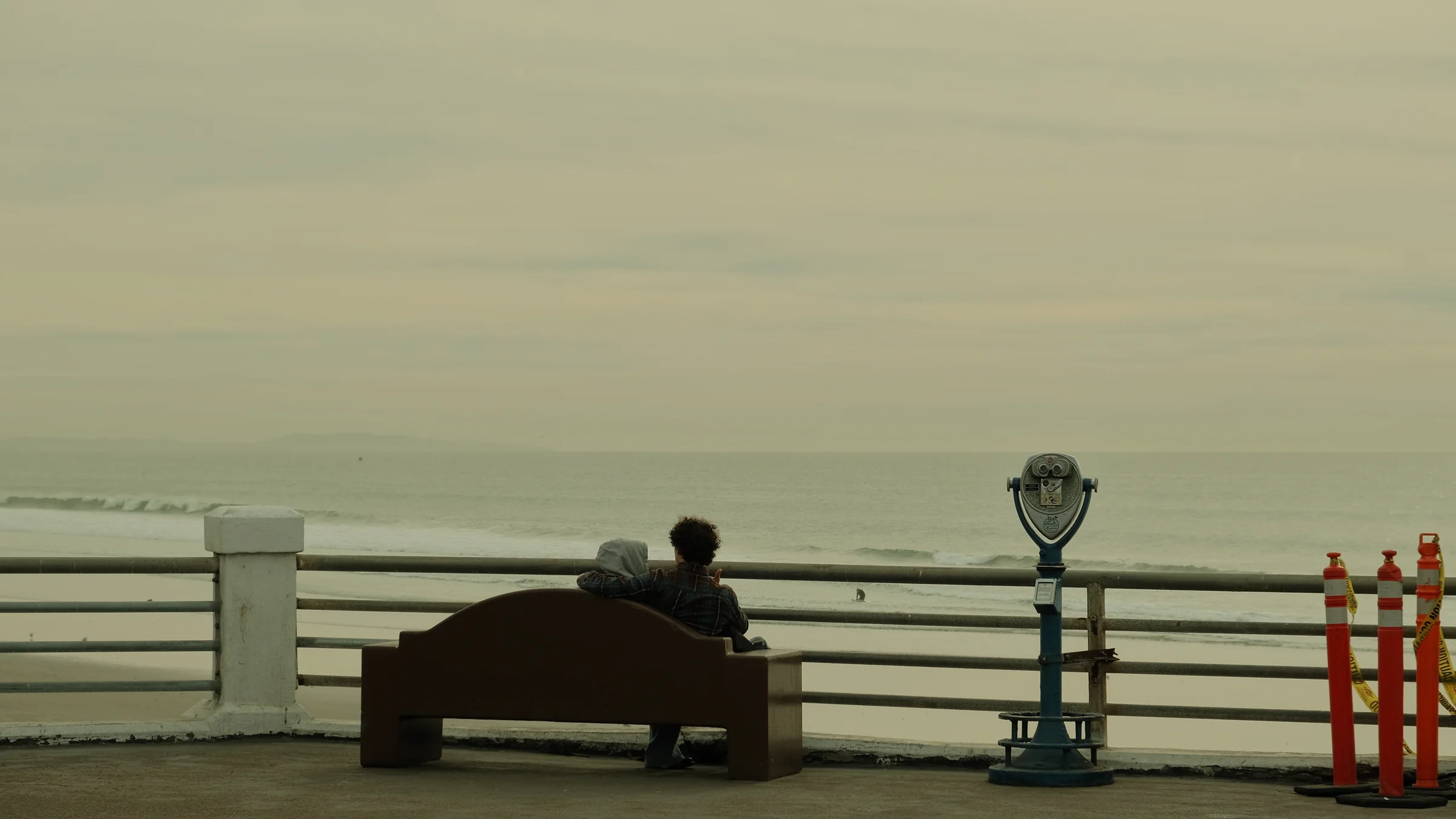 Foggy pier view with a bench and ocean telescope